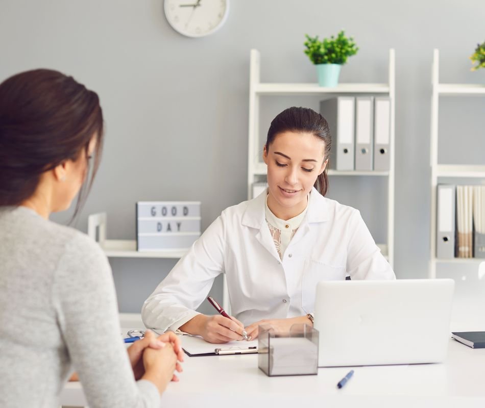 Fisioterapeuta atendiendo a una mujer en su mesa