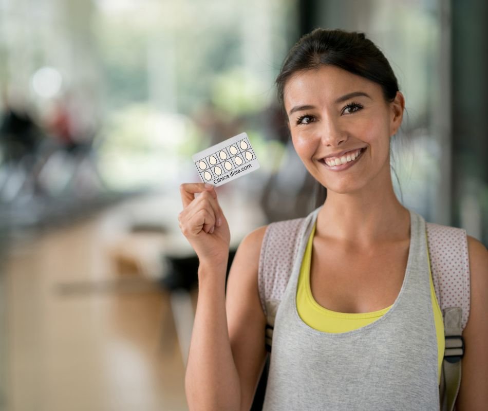 Clienta de fisioterapia joven y sonriente sosteniendo en la mano una tarjeta que representa el bono de 10 sesiones