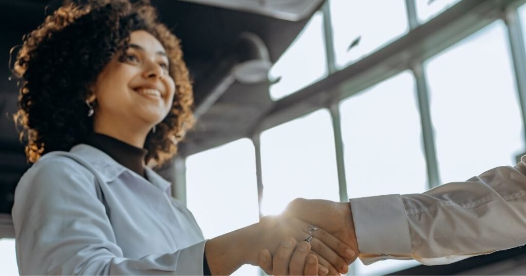 FISIOTERAPEUTA, dando la mano a una paciente sonriente