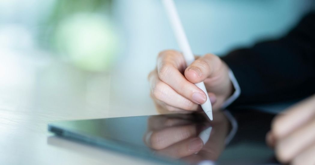 Persona firmando un consentimiento informado en clínica de fisioterapia en tablet